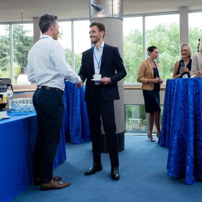 Business executives interacting with each other while having coffee at conference center