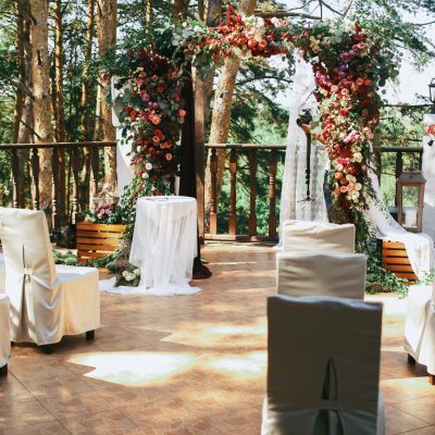 White chairs stand before wedding altar on the porch
